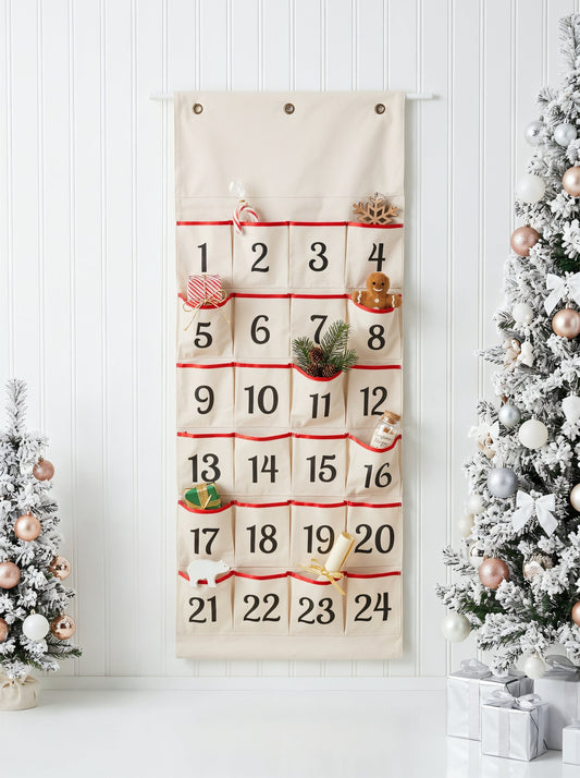 Natural canvas wall hanging advent calendar with 24 numbered red-trimmed pockets filled with small gifts, hung between two flocked Christmas trees - wholesale blank for HTV, embroidery and personalisation, KWC8497