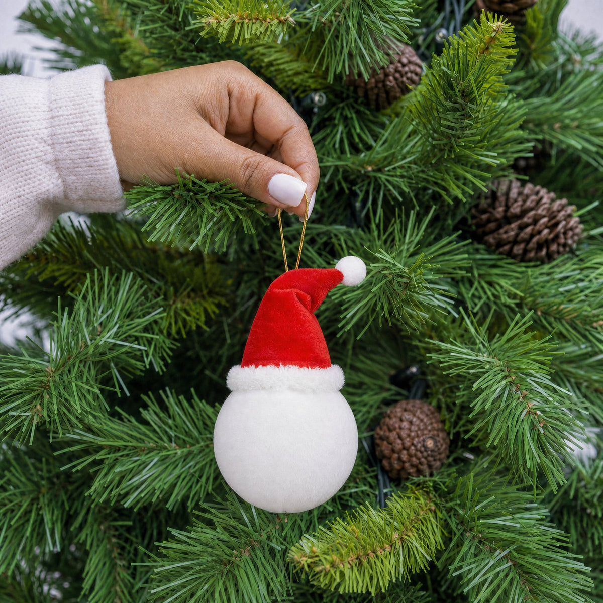 White plush Santa bauble decoration with red Santa hat and gold hanging string being hung on a Christmas tree - wholesale blank for personalisation, KWC6510