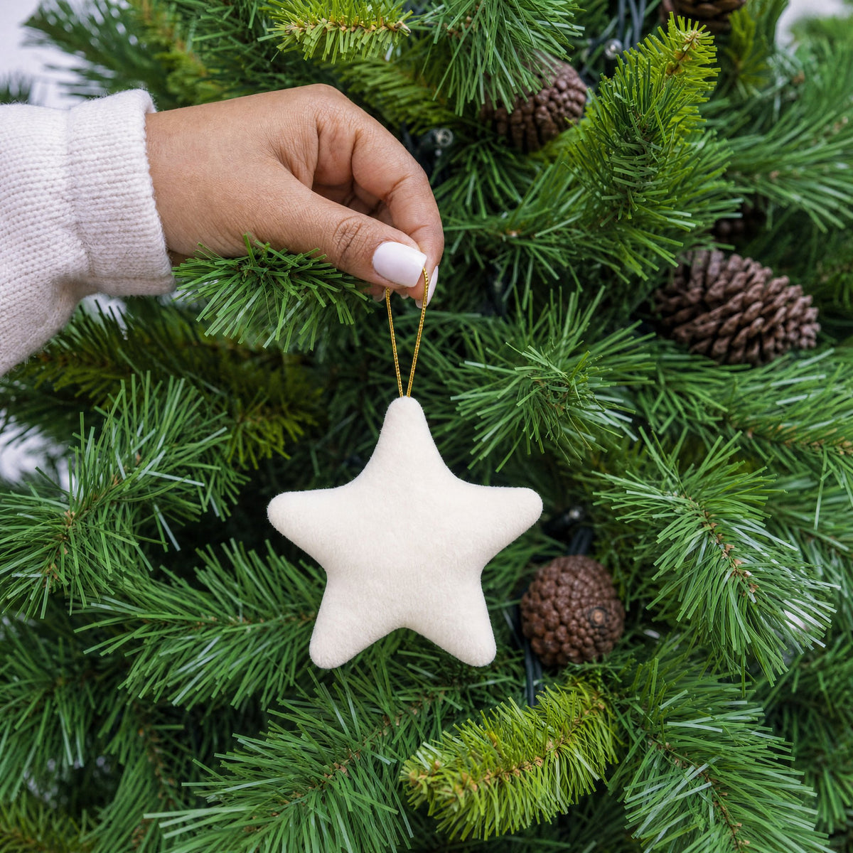Cream plush fabric star shape Christmas decoration with gold hanging string being hung on a Christmas tree - wholesale blank for personalisation, KWC2407C
