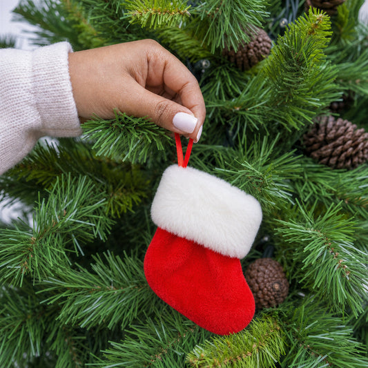 Red plush fabric mini stocking Christmas decoration with white fur cuff and red ribbon being hung on a Christmas tree - wholesale blank for personalisation, KWC9887