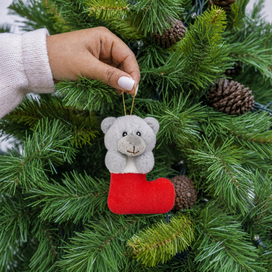 Grey plush teddy bear in red stocking Christmas decoration with gold hanging string being hung on a Christmas tree - wholesale blank for personalisation, KWC3354