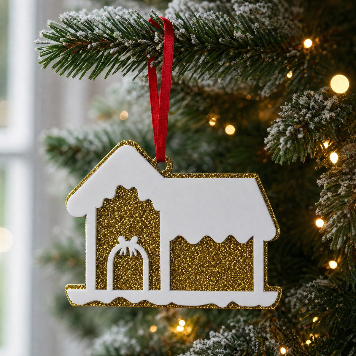 Gold glitter acrylic house decoration hanging on a Christmas tree